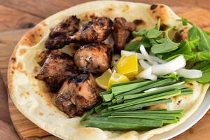 joojeh Kebab ou jojeh Kebab com bahraini pão tandoori nan, Lima e salada servido dentro prato isolado em de madeira mesa topo Visão meio Oriental grelha Comida foto