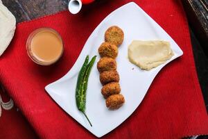 especiaria falafel com Húmus, café copo servido dentro prato isolado em vermelho esteira topo Visão em mesa árabe Comida foto