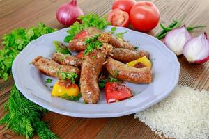 grelhado murmúrio ou linguiça grade com cebola, tomate e coentro servido dentro prato isolado em mesa lado Visão do árabe Comida foto