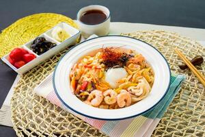 tailandês estilo picante misturado peixe udon Macarrão com camarão e camarão servido dentro tigela isolado em guardanapo lado Visão japonês Comida em mesa foto