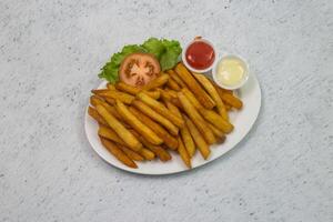 francês fritas com maionese mergulho e tomate ketchup molho servido dentro prato isolado em cinzento fundo topo Visão do Bangladeshi comida rápida foto