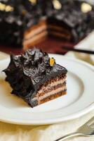 chocolate ganache bolo fatia servido dentro prato com faca isolado em guardanapo topo Visão do cafeteria assar Comida foto