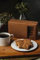 crocante biscoitos biscoitos servido dentro prato com bolacha caixa e Preto café isolado em mesa lado Visão do americano cafeteria cozido Comida foto