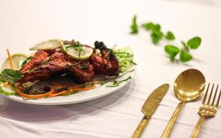 tandoori frango com limão fatia servido dentro prato isolado em mesa lado Visão do indiano especiarias Comida foto