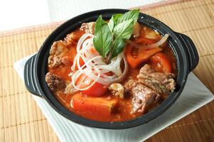 tomate e carne peito caçarola Macarrão servido dentro nascimento isolado em mesa topo Visão do pote de barro foto