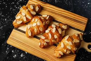 amêndoa croissant cobertura com nozes servido em de madeira borda topo Visão do francês café da manhã cozido Comida item foto