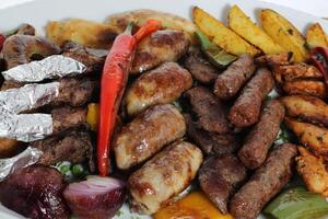 t Churrasquinho, frango, carne bovina, Carneiro, batata legumes, tomate e cebola servido dentro prato isolado em mesa topo Visão do árabe Comida foto