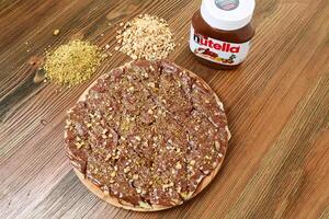 nutella chocolate torta com pistache e noz servido dentro de madeira borda isolado em mesa lado Visão do árabe Comida foto