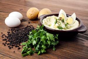 amassado batatas com fervido ovos coentro e Preto Pimenta servido dentro prato isolado em mesa lado Visão do árabe Comida foto