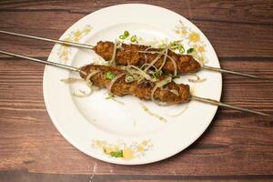 frango seeh kabab ou shikh Kebab tikka servido dentro prato isolado em de madeira mesa topo Visão indiano especiarias Comida foto