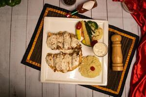 grelhado cogumelo frango piccata com brócolis salada, mergulhar, Preto Pimenta e alho Pimenta molho servido dentro prato isolado em guardanapo topo Visão em de madeira mesa italiano Comida foto