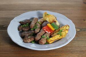 tikka Kebab e kofta misturar com batata legumes e salada servido dentro prato isolado em mesa topo Visão do árabe Comida foto