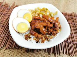 refogado carne de porco arroz com fervido ovo servido prato isolado em mesa topo Visão do tailandês Comida foto