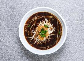 tailandês arroz macarrão dentro sopa servido dentro tigela isolado em cinzento fundo topo Visão do hong kong Comida foto