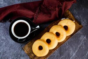 avião rosquinhas com copo do Preto café servido em de madeira borda isolado em guardanapo topo Visão do cozido Comida café da manhã em mesa foto