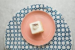 quadrado baunilha bolo servido dentro prato isolado em guardanapo topo Visão do cafeteria cozido Comida em fundo foto