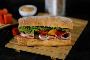 ciabatta defumado presunto sanduíche isolado em de madeira com maionese mergulho e francês fritas balde borda lado Visão do italiano velozes Comida em cinzento fundo foto