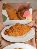 avião croissant servido dentro prato lado Visão do francês café da manhã cozido Comida item em cinzento fundo foto