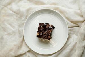 chocolate Brownie servido dentro prato isolado em guardanapo topo Visão do cafeteria cozido Comida em fundo foto