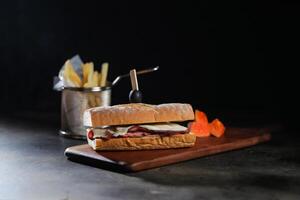 assado carne sub sanduíche com francês fritas balde servido em de madeira borda isolado em Sombrio fundo lado Visão do café da manhã Comida foto