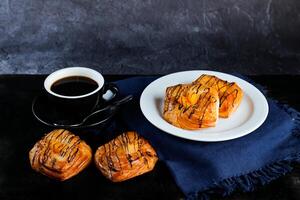 pêssego dinamarquês pastelaria sopro servido dentro prato com copo do Preto café isolado em guardanapo lado Visão do francês café da manhã cozido Comida item em cinzento fundo foto