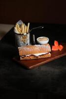 assado carne sub sanduíche com francês fritas balde servido em de madeira borda isolado em Sombrio fundo lado Visão do café da manhã Comida foto