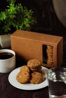 crocante biscoitos biscoitos servido dentro prato com bolacha caixa, Preto café e vidro do água isolado em mesa lado Visão do americano cafeteria cozido Comida foto