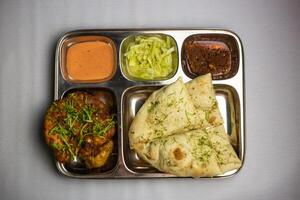 frango chaap com luchi, chuntney, molho e Pimenta mergulho servido dentro thali prato isolado em fundo topo Visão do Bangladeshi Comida conjunto cardápio foto