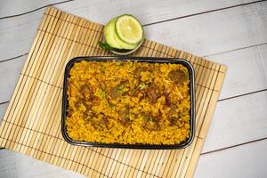 carne khicuri Biryani arroz pulao com pepino e limão fatia servido dentro prato isolado em de madeira mesa topo Visão do Bangladeshi e indiano picante Comida foto