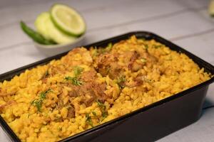 frango khicuri Biryani arroz pulao com pepino e limão fatia servido dentro prato isolado em de madeira mesa fechar-se lado Visão do Bangladeshi e indiano picante almoço Comida foto