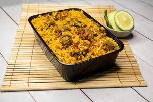 carne khicuri Biryani arroz pulao com pepino e limão fatia servido dentro prato isolado em de madeira mesa lado Visão do Bangladeshi e indiano especiarias almoço Comida foto