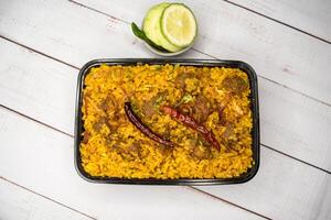 achari carne khicuri Biryani arroz pulao com pepino e limão fatia servido dentro prato isolado em de madeira mesa topo Visão do Bangladeshi e indiano picante almoço Comida foto