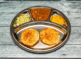 podi Idli com Curry thali servido dentro prato isolado em de madeira mesa topo Visão do indiano picante Comida foto