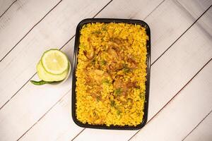 frango khicuri Biryani arroz pulao com pepino e limão fatia servido dentro prato isolado em de madeira mesa fechar-se topo Visão do Bangladeshi e indiano picante almoço Comida foto