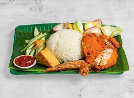 ayam penyet com arroz, salada e Pimenta molho servido dentro prato isolado em banana folha topo Visão do Cingapura Comida foto