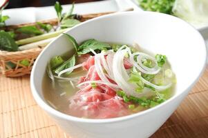 a nam cru carne sopa pho servido dentro tigela isolado em mesa topo Visão do sopa pó foto