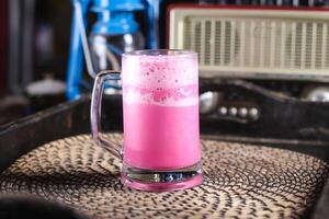 rosa leite xarope ou gulab mexe servido dentro caneca isolado em vermelho esteira topo Visão em mesa árabe beber foto