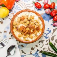 fattah Húmus servido dentro prato isolado em mesa topo Visão do árabe Comida foto