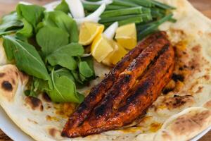 frango recheado com queijo carne seeh Kebab com bahraini pão tandoori nan, Lima e salada servido dentro prato isolado em de madeira mesa topo Visão meio Oriental grelha Comida foto