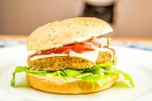 frango hamburguer com queijo fatiar, ketchup, tomate e alface folha servido dentro prato isolado em mesa topo Visão do árabe Comida foto