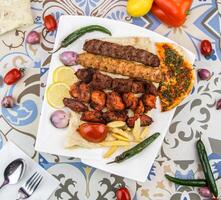 sortido misturar grelha com tikka boti seeh kabab do frango, carne bovina, cordeiro, Carneiro, fritas, Pão Pita pão churrasco prato servido dentro prato isolado em mesa topo Visão do árabe Comida foto