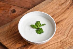 pepino e hortelã iogurte raita servido dentro prato isolado em de madeira mesa topo Visão meio Oriental aperitivos Comida foto