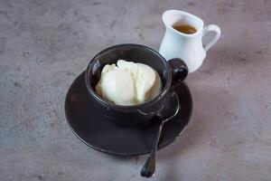 quente affogato servindo dentro café copo com colher e feijões lado Visão em cinzento fundo foto