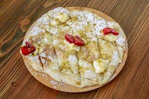 creme e nozes torta com pistache servido dentro de madeira borda isolado em mesa lado Visão do árabe Comida foto