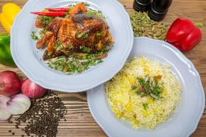 metade grelhado frango com pulao arroz Biryani, Preto pimenta, Sino pimentas, tomate e cebola servido dentro prato isolado em mesa topo Visão do árabe Comida foto