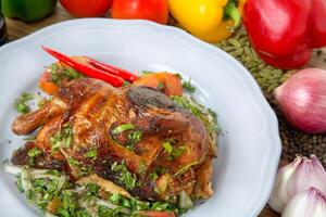 cheio grelhado frango com Sino pimenta, tomate, cebola, Preto Pimenta e cardamomo servido dentro prato isolado em mesa lado Visão do árabe Comida foto