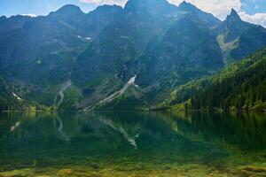 montanhas alcance perto lago às verão dia foto