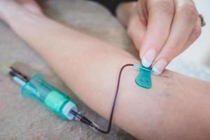 tecnólogo médico fazendo serviços de coleta de sangue para o paciente. foto