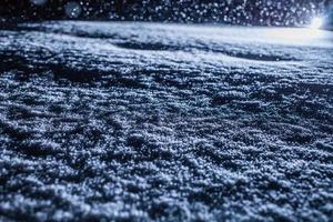 textura de neve iluminada por trás durante tempestade de neve à noite foto