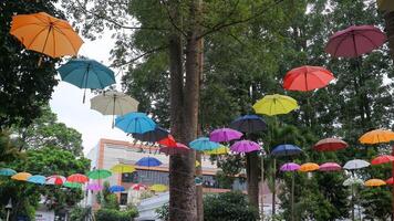 colorida guarda-chuvas suspensão contra uma azul céu fundo foto